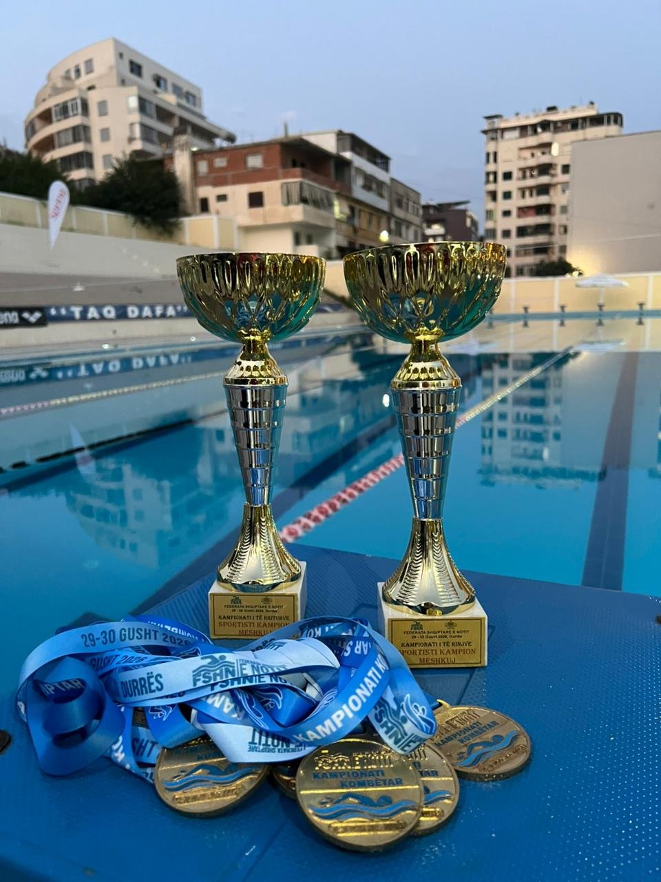 Two national championship trophies and medals on the starting block